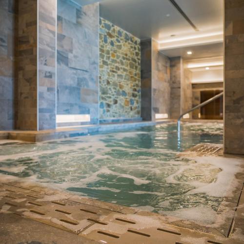 a pool of water in a room with a stone wall at Le Cappuccinelle Suites&SPA in Perugia