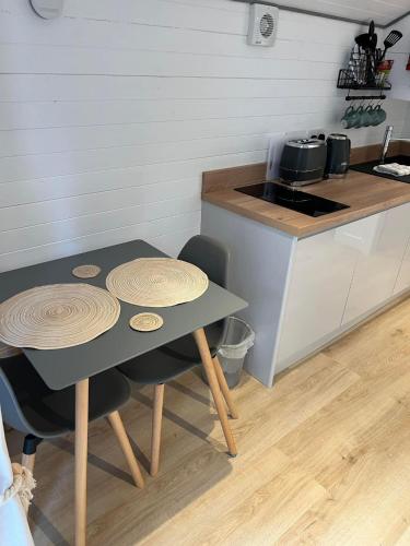 a kitchen with a table and two chairs and a counter at Pod at Lonan drive in Oban