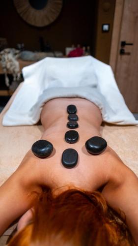 a man laying on a bed with black rocks on his back at Regia Mare Beach Hotel & Spa Bodrum in Ortakent