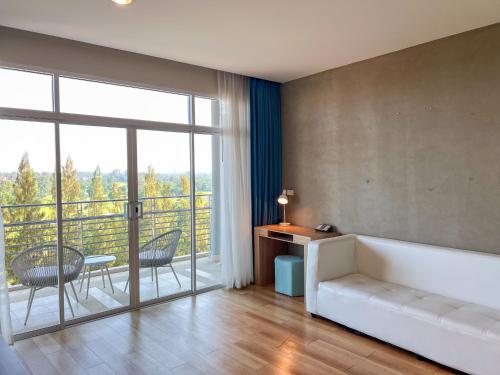 a living room with a couch and a large window at The Kaset, Hua Hin in Hua Hin