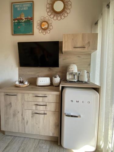 a small kitchen with a refrigerator and a tv at L'Estrambord de Camargue in Saintes-Maries-de-la-Mer