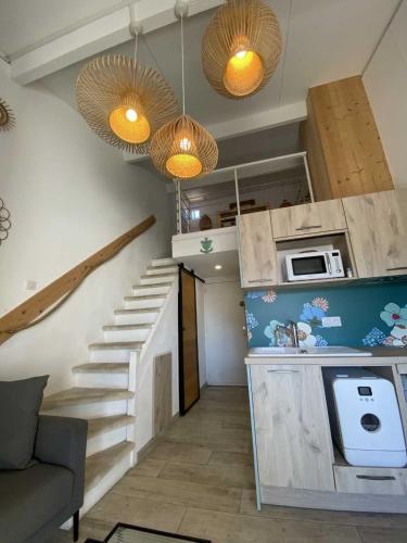 a living room with a staircase and a microwave at L'Estrambord de Camargue in Saintes-Maries-de-la-Mer