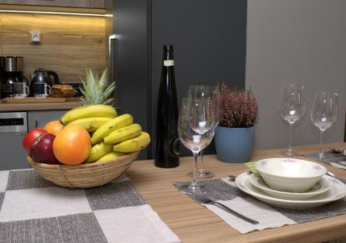 a bowl of fruit on a table with wine glasses at VENUS GUESTHOUSE in Portariá