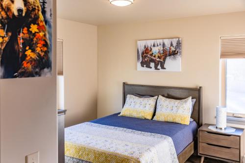 a bedroom with a bed with blue sheets and yellow pillows at Lakeshore Lodging Suites in Homer