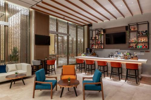 a lobby with a bar with chairs and a couch at DoubleTree by Hilton Vientiane in Vientiane