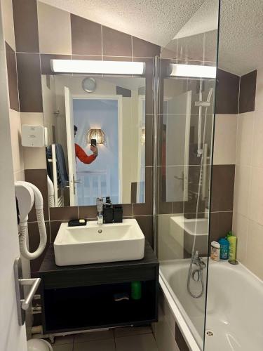 une personne prenant une photo d'une salle de bains avec lavabo et douche dans l'établissement Duplex magnifique pour accueillir jusqu'à 6 personnes, à Arles