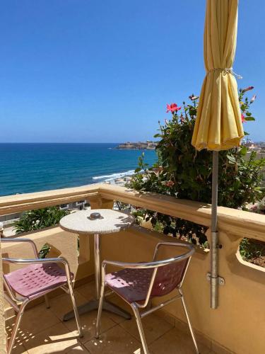 a patio with a table and chairs and an umbrella at Eliza Apartments in Rethymno Town