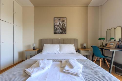 a bedroom with a bed with two towels on it at AIOLOS elegant escapes GLYFADA apartment in Athens