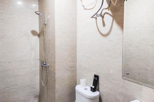 um banheiro com chuveiro, vaso sanitário e pia em Luxurious and Comfy 2BR at Vida View Makassar Apartment By Travelio em Pampang