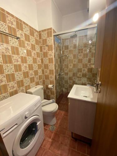 a bathroom with a toilet and a washing machine at Eliza Apartments in Rethymno Town
