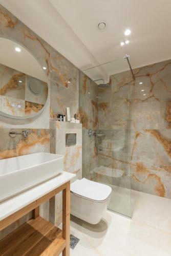 a bathroom with a toilet and a sink and a shower at The Wine Hotel in Rhodes Town