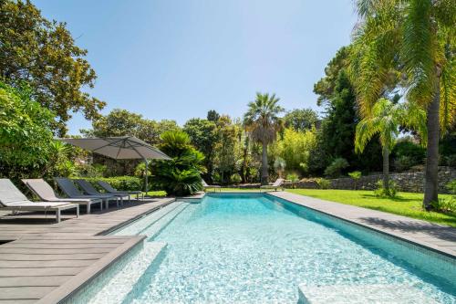 - une piscine avec des chaises longues et un parasol dans la cour dans l'établissement REF 1941 - Cannes Center - Villa for rent, à Cannes