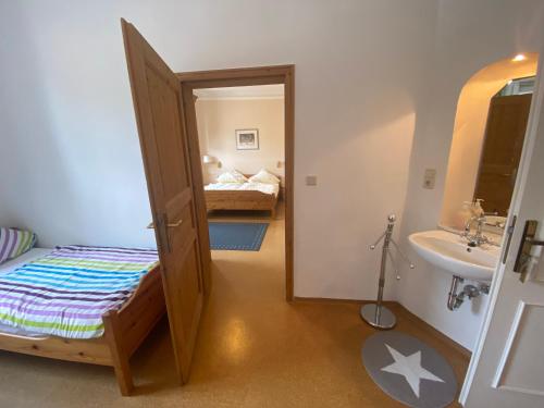 a small bedroom with a bed and a sink at Landgasthof Goldener Löwe Mainbernheim in Mainbernheim