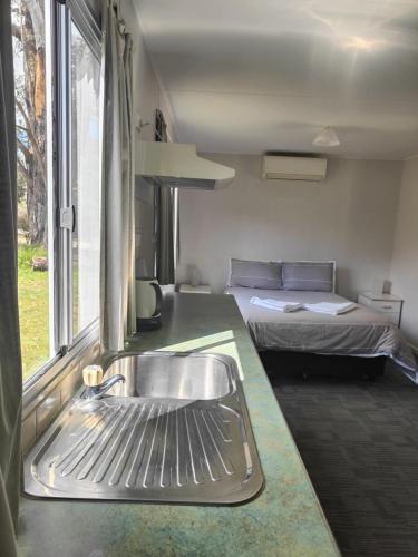 a kitchen with a sink and a bed in a room at Mt Barker Holiday Park - Western Australia in Mount Barker