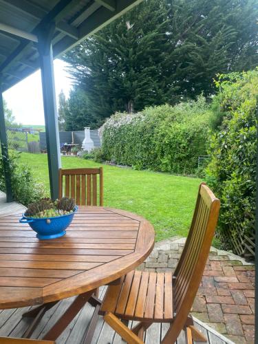 a wooden table and two chairs on a patio at Cherry Tree Cottage in Lawrence