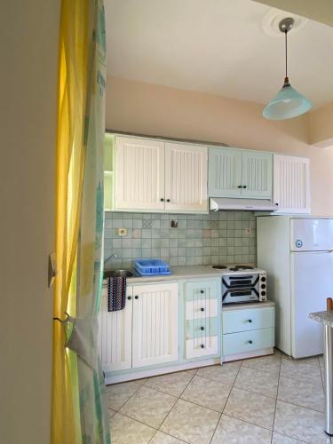 a kitchen with white cabinets and a white refrigerator at Eliza Apartments in Rethymno Town