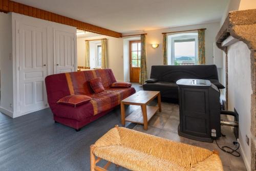 a living room with a couch and a chair at Gîte Gîte de l'Ancien Presbytère 6/8 personnes in Saint-Paul-le-Froid