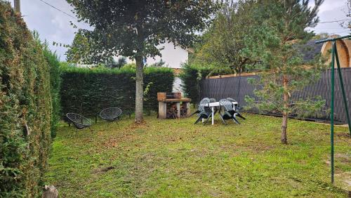 a yard with a table and chairs and a fence at Maison familiale avec jardin clos et barbecue in Le Puy en Velay