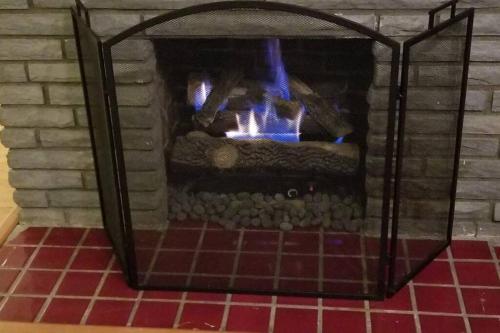 a brick fireplace with a fire in it at Mt Washington #1 on Grandview at Gazebo Park in Pittsburgh