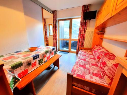 Cette chambre comprend un lit, une table et un banc. dans l'établissement Résidence Jetay - Appartement 4 personnes aux Ménuires MAE-5564, aux Menuires