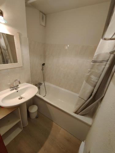 une salle de bain avec un lavabo et une baignoire et un lavabo dans l'établissement Ambiance chalet et belle terrasse, à Thollon-les-Mémises