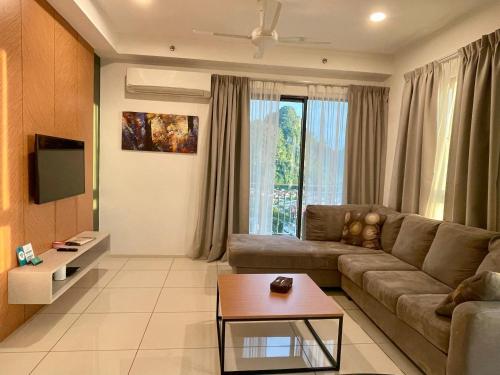 a living room with a couch and a table at JOMSTAY Sunway Onsen Suites Ipoh - Lost World of Tambun Ipoh Waterpark in Tambun