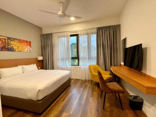 a hotel room with a bed and a desk and a desk at JOMSTAY Sunway Onsen Suites Ipoh - Lost World of Tambun Ipoh Waterpark in Tambun