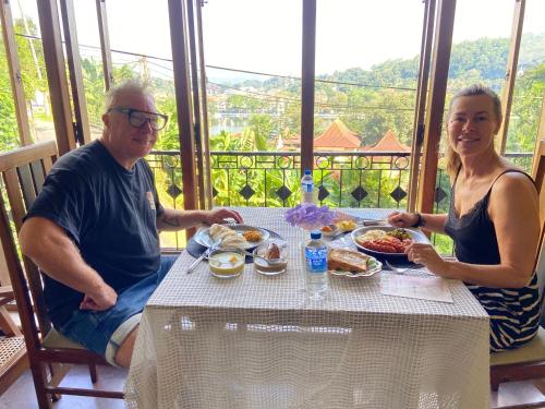 a man and a woman sitting at a table with food at Sesatha lake Kandy in Kandy