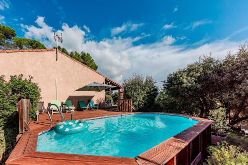 une piscine avec une terrasse en bois et une maison dans l'établissement La Sauvergine - Maison 8 personnes parc du verdon, à Sillans-la-Cascade