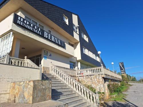 a building with stairs in front of a building with a sign at Hotel Berna in La Rúa