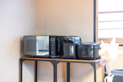 a microwave and other appliances sitting on a shelf at Muji Arashiyama Villa 無時嵐1階2階賃貸し 駅まで徒歩2分 in Kyoto
