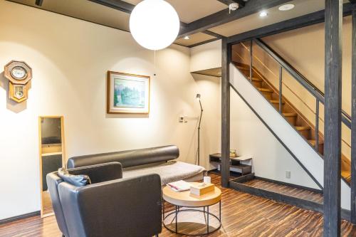 a living room with a couch and a staircase at Muji Arashiyama Villa 無時嵐1階2階賃貸し 駅まで徒歩2分 in Kyoto