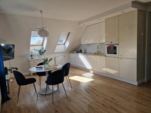 a kitchen and dining room with a table and chairs at Złoty Apartament - Okrzei z miejscem parkingowym, dostęp 24H, Klimatyzacja in Kielce