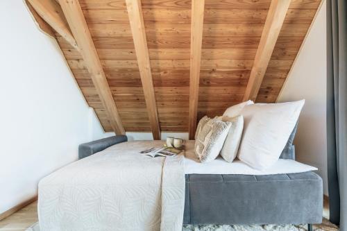 a room with a bed with a wooden ceiling at Apres Ski Bachleda - LoftAffair Collection in Zakopane