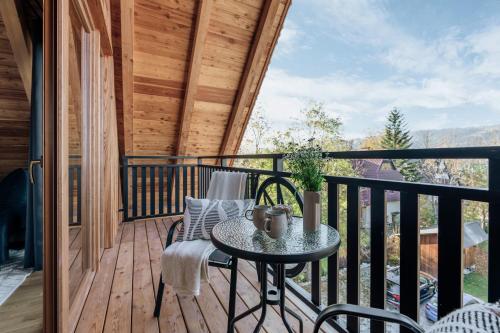 a patio with a table and chairs on a balcony at Apres Ski Bachleda - LoftAffair Collection in Zakopane