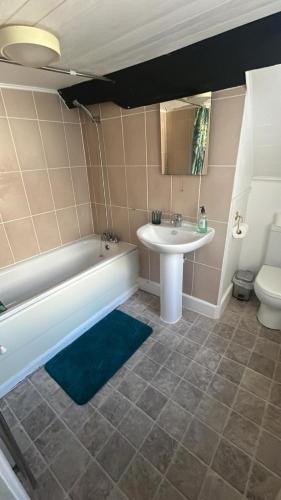 a bathroom with a tub and a sink and a toilet at Amazing value, in great location in Plymouth