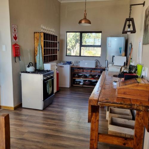 a kitchen with a wooden table in a room at The Fat Mulberry Guest Farm in Fouriesburg