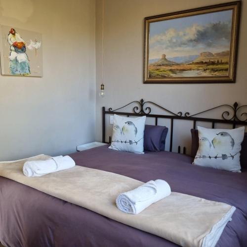 two beds in a bedroom with two white towels on them at The Fat Mulberry Guest Farm in Fouriesburg