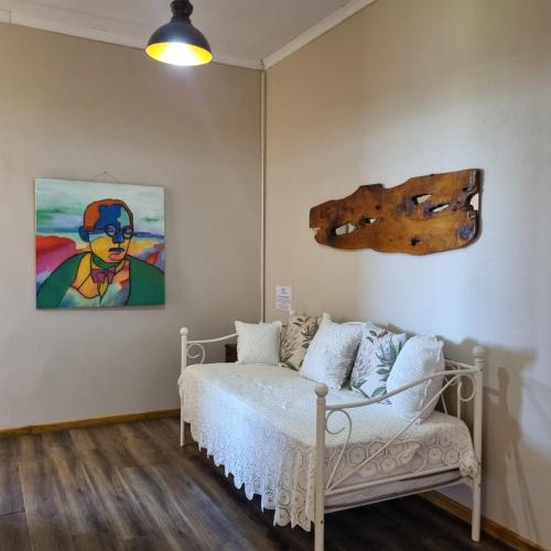 a bedroom with a bed and a painting on the wall at The Fat Mulberry Guest Farm in Fouriesburg