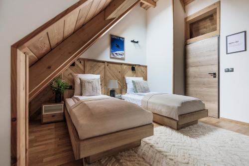 two beds in a room with a staircase at Apres Ski Bachleda - LoftAffair Collection in Zakopane