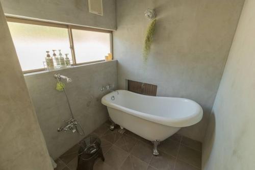 a white bath tub in a bathroom with a window at La toile in Mitoyo