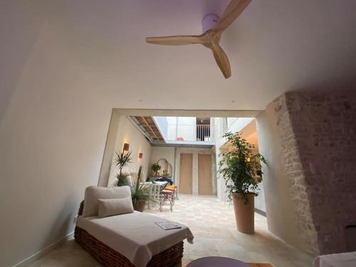 - un salon avec un ventilateur de plafond et un canapé dans l'établissement La Maison Naturospa, à Chaumont