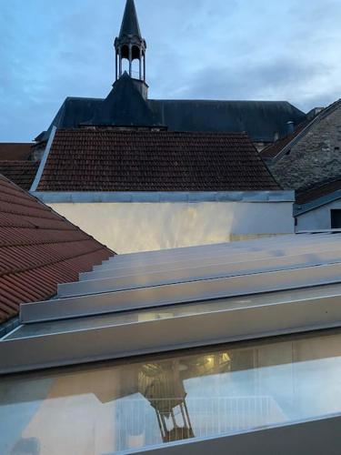 un bâtiment avec une tour d'horloge au sommet dans l'établissement La Maison Naturospa, à Chaumont