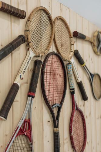 four tennis rackets are hanging on a wall at Apres Ski Bachleda - LoftAffair Collection in Zakopane