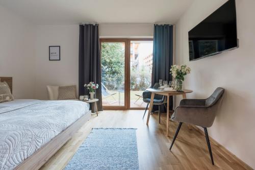 a bedroom with a bed and a table with a dining room at Apres Ski Bachleda - LoftAffair Collection in Zakopane