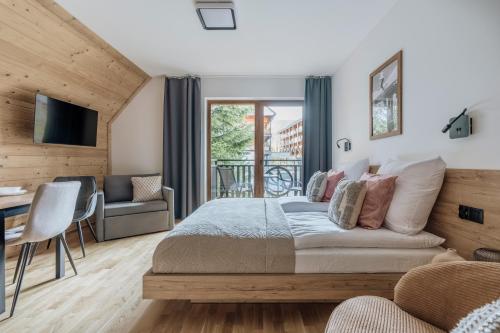 a bedroom with a bed and a desk and a chair at Apres Ski Bachleda - LoftAffair Collection in Zakopane