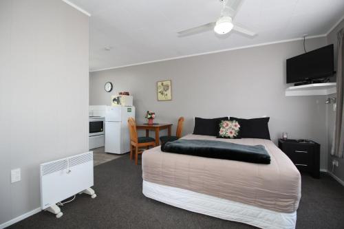 a bedroom with a bed and a table and a kitchen at Ormond Street Motel Woodville in Woodville