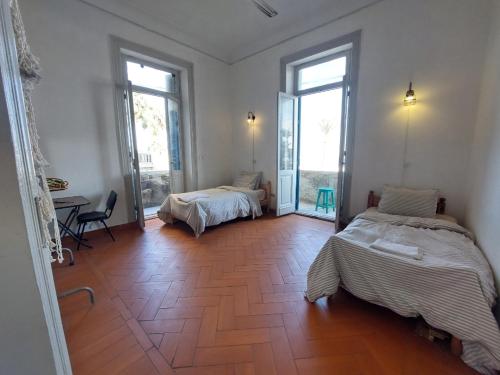 a room with two beds and a table and windows at Alexandria private rooms, Only For Men 仅限男士 in Alexandria