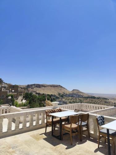 a balcony with tables and chairs and a view of the ocean at Rumetpaşakonağı in Mardin