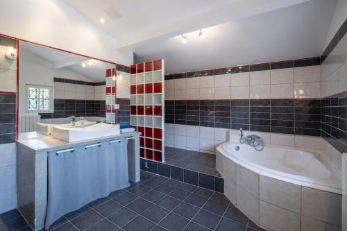 une salle de bain avec une baignoire et un lavabo et une baignoire dans l'établissement Villa Lumineuse avec Piscine Chambres OU Villa, à Saint-Georges-dʼOrques